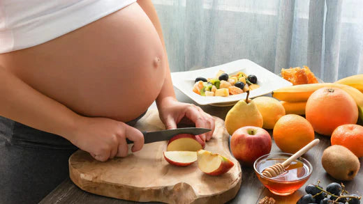 pregnant women cutting apples with mad honey on side