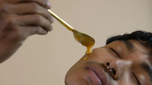 a man pouring mad honey on his face