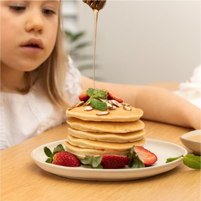 A girl applying honey in pastries and cookies