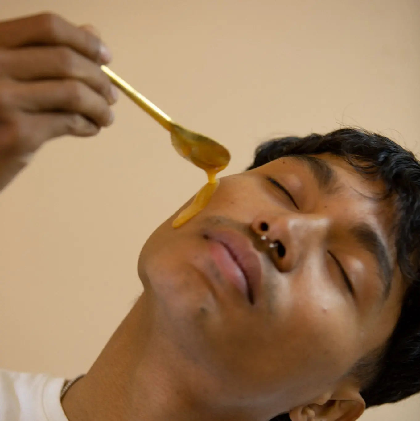 Man pouring mad honey on skin