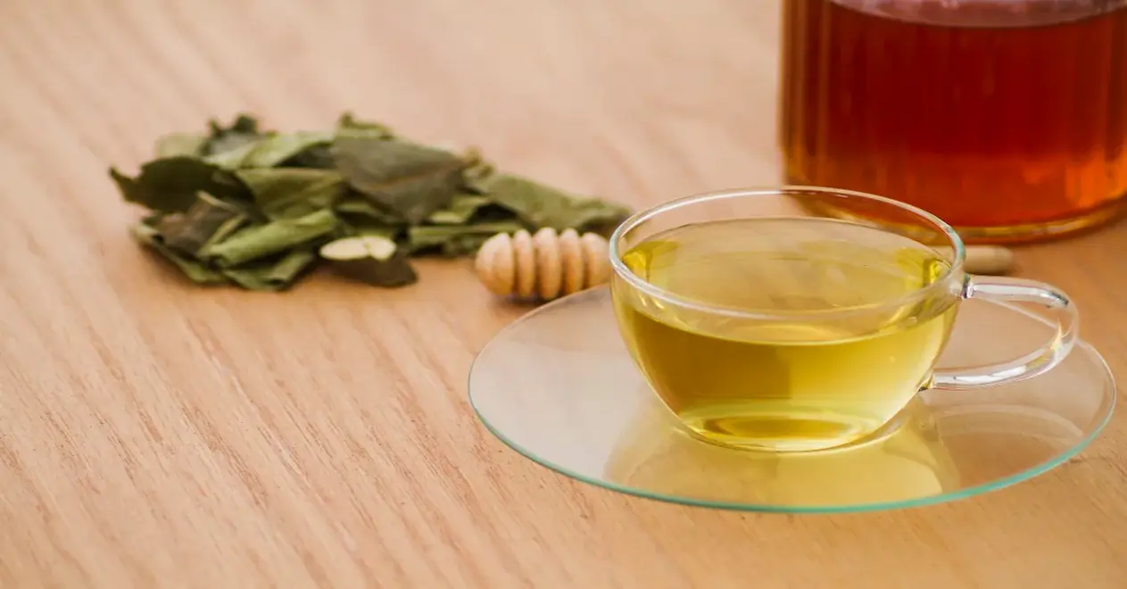 druipende honing in groene thee